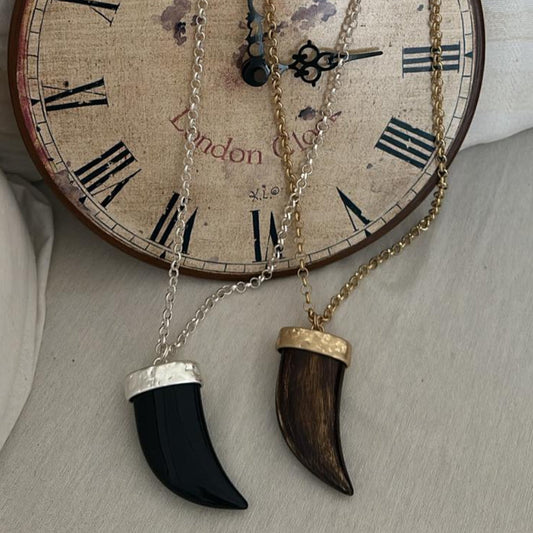 Collar Talismán con colgante de resina negro y marrón sobre reloj vintage